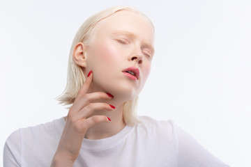 Professional model with red nail art closing eyes while posing