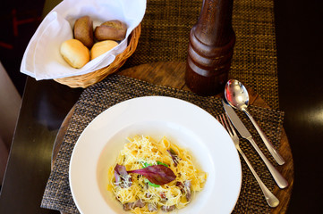 Pasta with melted cheese and pieces of meat on a plate