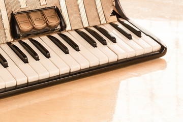 detail of old accordion on wooden table in vintage tone, close up. music concept