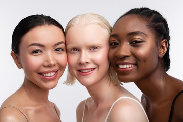 Three women smiling while thinking about women power