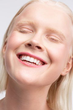 Cheerful blonde woman with white eyebrows smiling broadly