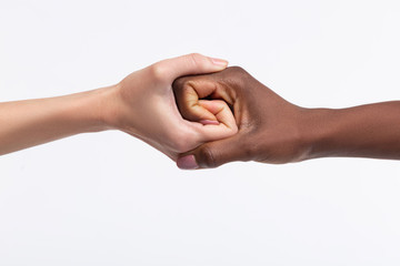 Two women with different skin color shaking their hands