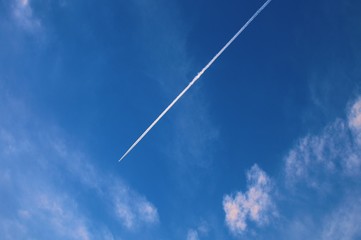 airplane in the blue sky with white clouds