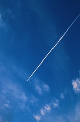 airplane flying in the blue sky with white clouds