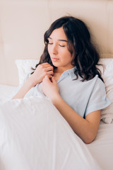 Young beautiful woman sleeping in bed, relaxing in the morning