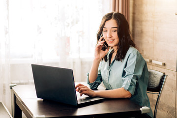 Happy young woman using laptop at home