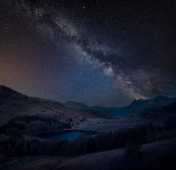 Fototapeta na wymiar Digital composite image of Milky Way over beautiful landscape image of Blea Tarn in UK Lake District