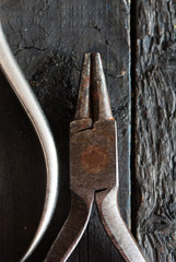 old pliers on black wood background directly above