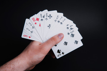 Obraz premium Handsome male hand holding playing cards, dark isolated background