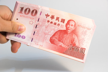 A hand holding Taiwan money on isolate white background