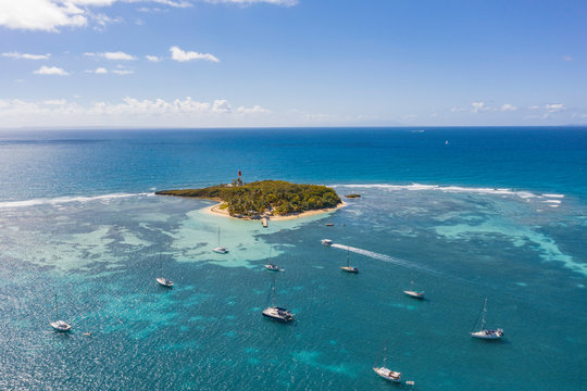 Scenic aerial view of Le Gosier island  near La Datcha beach in Guadeloupe. Beautiful summer sunny look of small paradise tropical island in Caribbean sea. Several boats and yachts in blue sea.