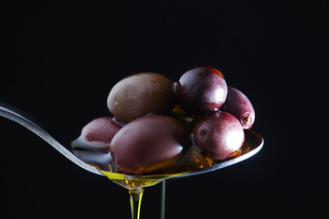 A spoon full of black olives