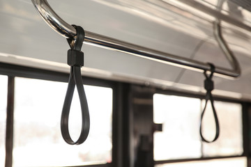 Upper handrail in bus. Bus handhold. black strap on the handrail in the bus. bus accessories hand...