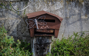 Boîte au lettres artisanales construites avec de la tole rouillée et décorée d'un papillon en fer forgé. Sur les bords du canal de Lunel dans le sud de la France. Dans l'Hérault, Occitanie, Languedoc 