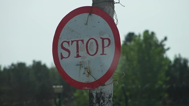 Steady, close up, exterior shot of a circular stop sign.