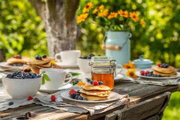 Homemade pancakes for breakfast in sunny garden - obrazy, fototapety, plakaty