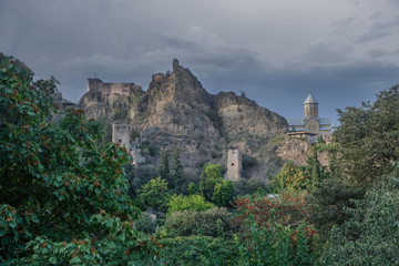 Dramatic view of the mountains and Narikala fortress from the botanical garden in the city of Tbilisi in stormy weather 