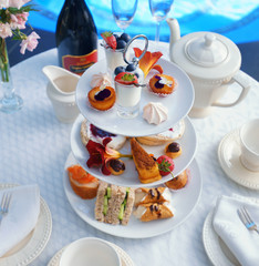 A posh high tea laid out on a cake stand with fancy cakes and pastries