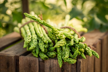Closeup of healthy green asparagus on a wooden box - obrazy, fototapety, plakaty