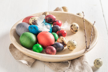 Various eggs for Easter on clay plate on white table