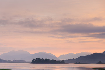 Naklejka na ściany i meble beautiful mystic sunset at glencoe and loch leven with fog and clouds