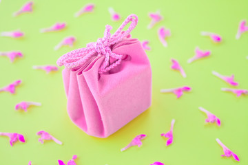 Closeup of a small gift wrapped with pink ribbon. Small gift box. Shallow depth of field. Flat lay, top view.