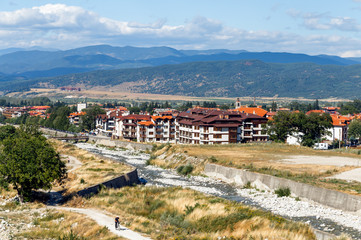 Fototapeta na wymiar View of Bansko town, bulgarian ski resort in summer, Pirin Mountains in the background, a river in the foreground, Bulgaria.