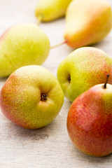 Fresh pears with leaves in a on wooden background.