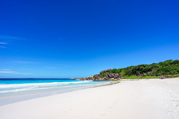 White sand, palm trees, granite rocks and turquoise water at the paradise beach at grand anse, la digue, seychelles 6
