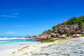 Fototapeta na wymiar Coral reef and big granite rocks with palms at the beach of grand anse, la digue, seychelles 2