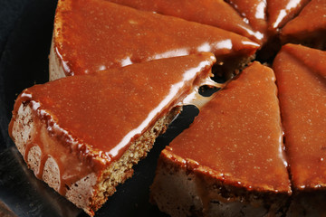 pie with caramel close up on dark background. cake with banana and caramel