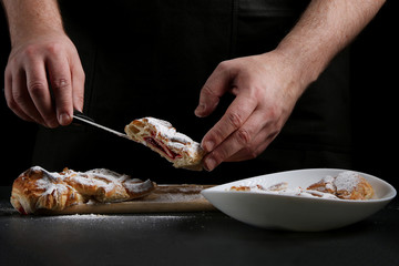 man in apron serving strudel. recipe of strudel or pie. baker decorating concept