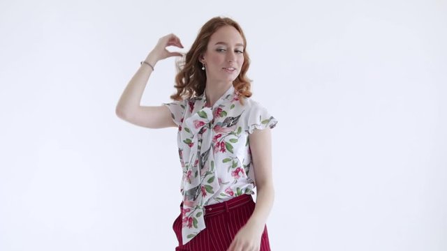 Sexy model with red hair posing on white background, slow mo
