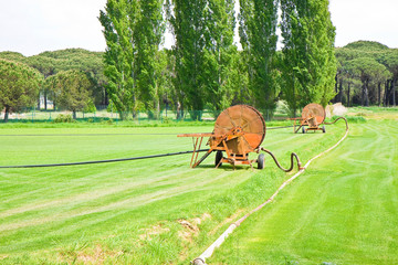 Metal irrigator in a green mowed lawn