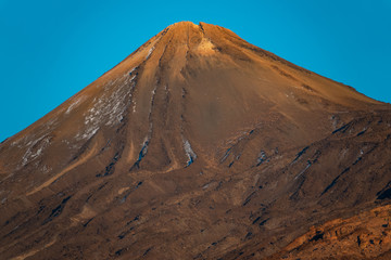 Teide mountain peak crater at dusk against blue sky