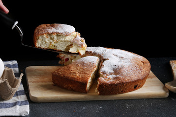 chef serves the pie on dark background. pie recipe concept