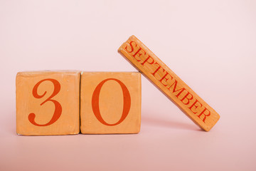 september 30th. Day 30 of month, handmade wood calendar  on modern color background. autumn month, day of the year concept