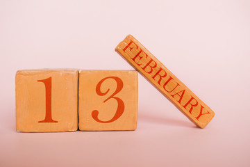 february 13th. Day 13 of month, handmade wood calendar  on modern color background. winter month, day of the year concept