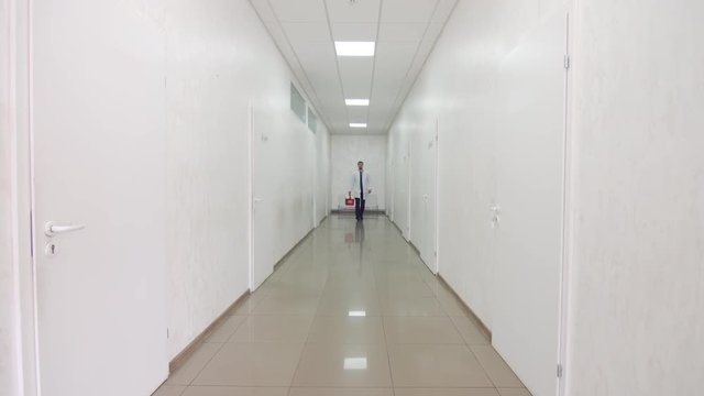 Doctor with organ trafficking container at the hospital corridor