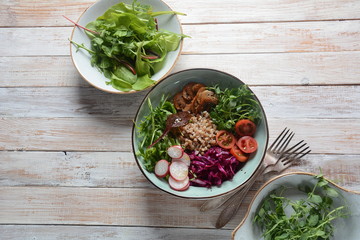 Vegan Buddha bowl with buckwheat, avocado, boiled eggs, cucumber, arugula beet leaves. Diet, detox, healthy food concept 