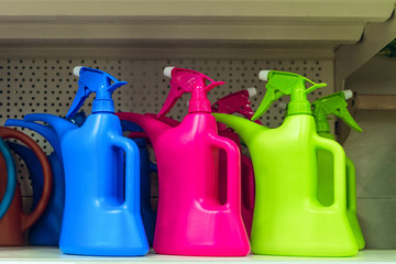 Colored plastic watering spray cans on the shelf