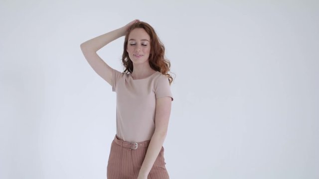 Sexy model with red hair posing on white background, slow mo