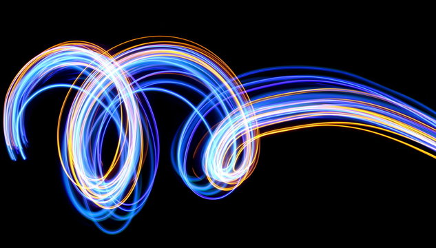 Light painting photography, blue and gold loops and swirls of vibrant color, long exposure photo of fairy lights against a black background © LizFoster