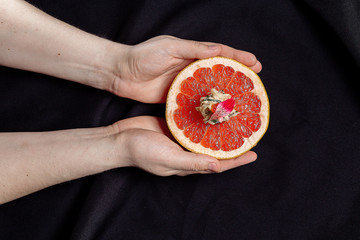 grapefruit on a black background in the hands of the chef
