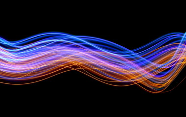 Light painting photography, blue and gold waves and swirls of vibrant color, long exposure photo of fairy lights against a black background