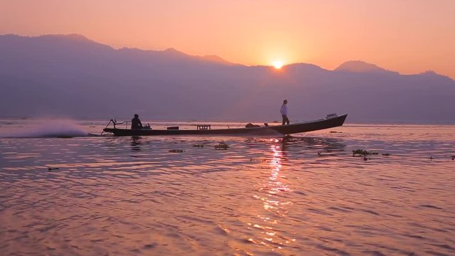 IRRAWADDY RIVER, MYANMAR. Female tourist explores rural waterscape during colorful sunset. Picturesque panorama of wide water plain.