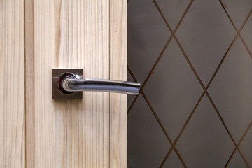 Steel door, wood trim. Several locks and a handle. Hotel door with modern knob for background.