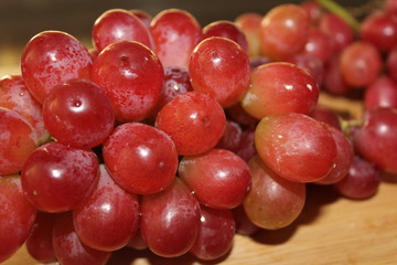 Red grapes on a wooden board
