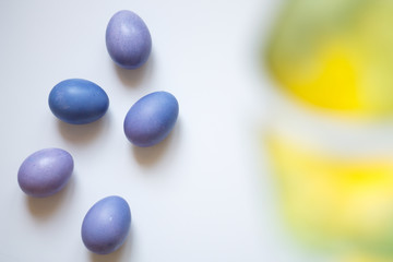 dyed eggs purple with a green leaf on a light background of Easter