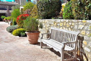Fototapeta na wymiar garden bench near the stone wall in Provence, France